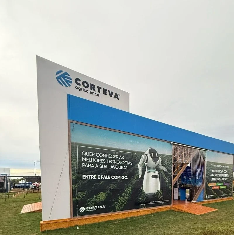complacampo 2025: Estande da Corteva Agriscience na Coplacampo 2025, com fachada e painéis em preto e azul, mensagem promocional e um robô humanizado em destaque no evento