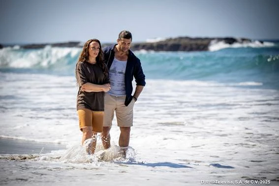 Confira a seguir o resumo dos capítulos 5, 6 e 7 de A.MAR: Marina e Gabriel caminhando na praia, com ondas ao fundo, em uma cena ao ar livre durante o dia