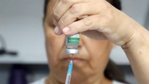 Profissional de saúde aplicando dose da vacina contra a gripe em paciente em uma Unidade Básica de Saúde (UBS) de Campinas.