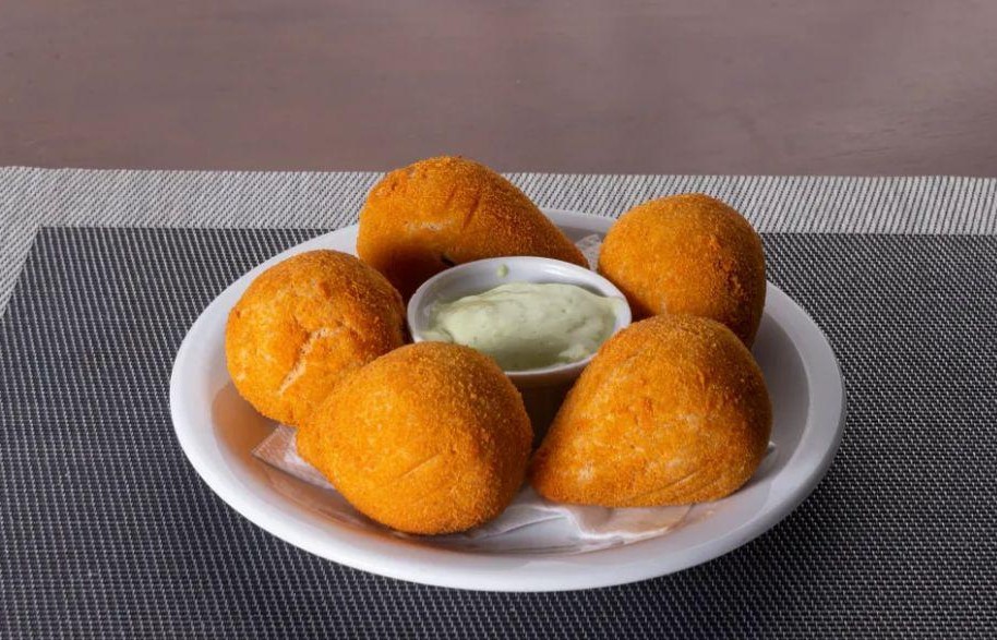 Coxinhas fritas e douradas servidas pelo Distrito Bar e Restaurante como opção de petisco promocional em Campinas.