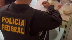 Agentes da Polícia Federal realizando buscas e apreensões de materiais digitais em investigação na região de Campinas.