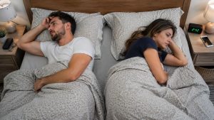 Casal dormindo abraçado de forma confortável e tranquila, transmitindo a sensação de intimidade e conexão ao dormir ao lado de quem se ama.
