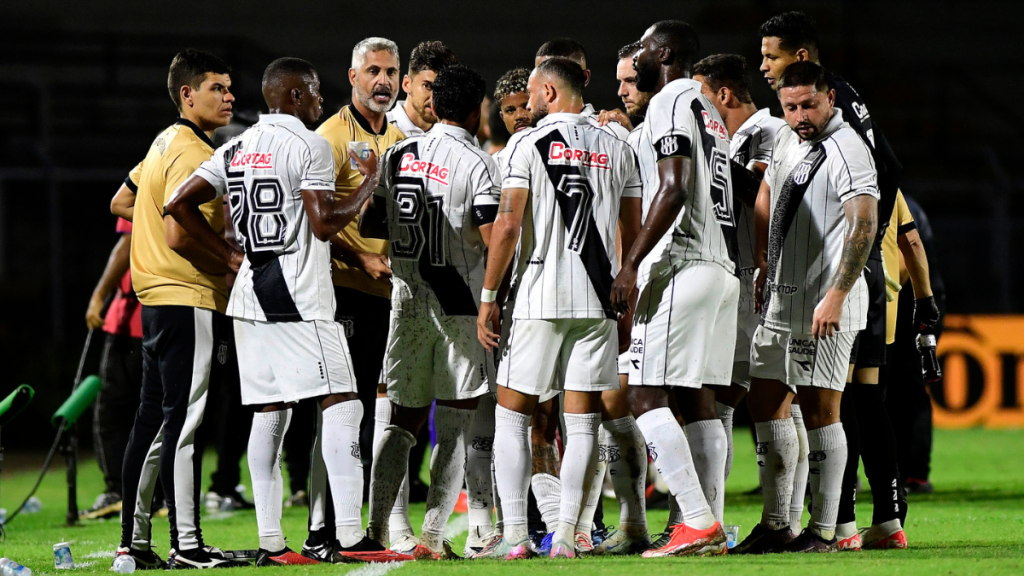 Jogadores do elenco da Ponte Preta reunidos no gramado durante atividade oficial do clube.