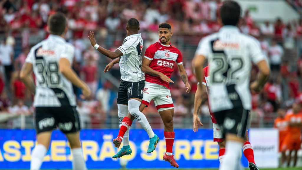 Jogadores de CRB e Ponte Preta em disputa de bola durante partida válida pela Série B no Estádio Rei Pelé.