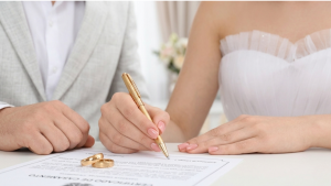 Casal assinando documentos de registro civil em cartório para oficializar a união matrimonial em 2026.