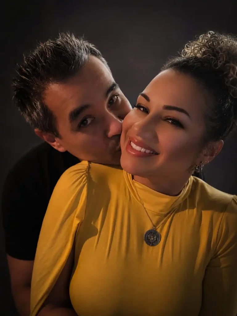 Nathy e Bruno sorridentes durante comemoração de Dia dos Namorados em uma casa de swing, exemplificando a quebra de rotina nos relacionamentos.