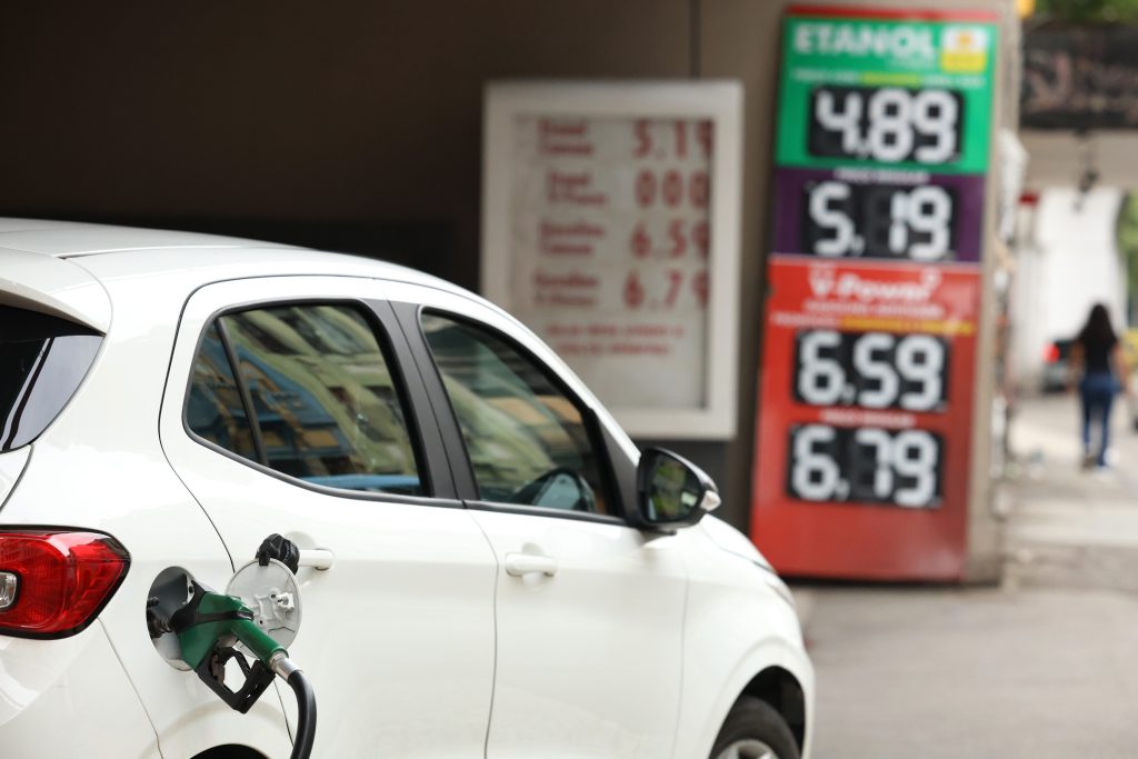 Foco em bombas de combustível em um posto de gasolina, ilustrando a aplicação do subsídio de R$ 0,44 por litro estabelecido pelo governo federal.
