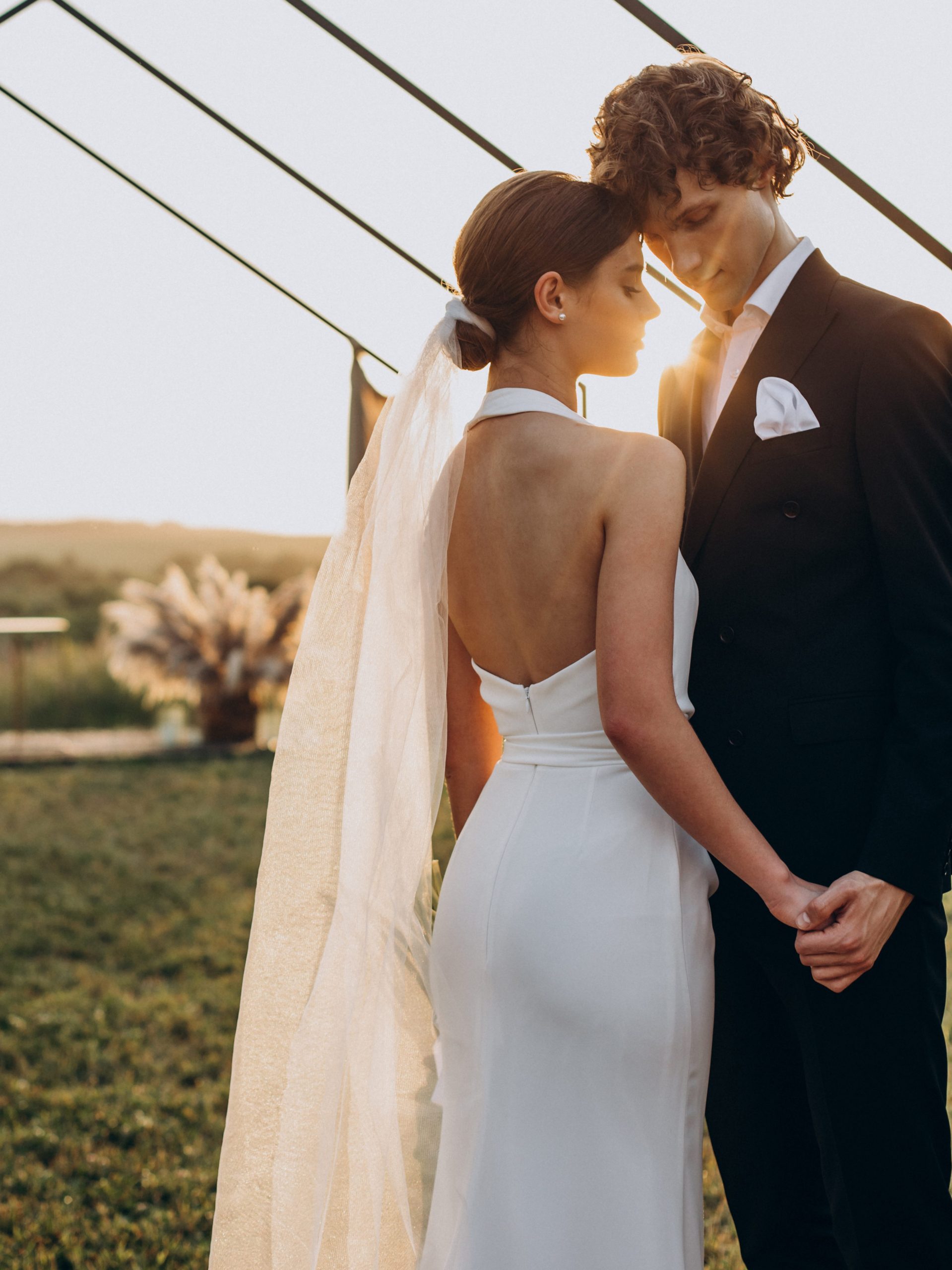 Casal de noivos durante cerimônia de casamento ao ar livre e intimista, exemplificando a tendência de celebrações leves que fogem do tradicional.