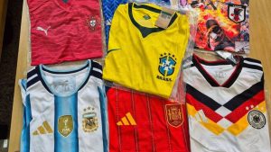 Milhares de camisas de seleções e clubes de futebol falsificadas empilhadas após apreensão da Receita Federal no Porto de Santos.