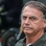 Jair Bolsonaro em foto ao ar livre, com expressão séria, em contexto de debate sobre PGR defendendo a manutenção de restrições impostas por Moraes.