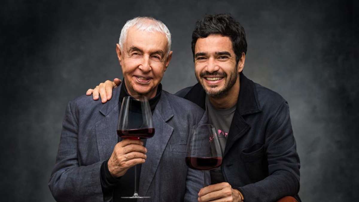 Os atores Caio Blat e Elias Andreato em cena do espetáculo Memórias do Vinho, representando o reencontro entre pai e filho em uma adega.