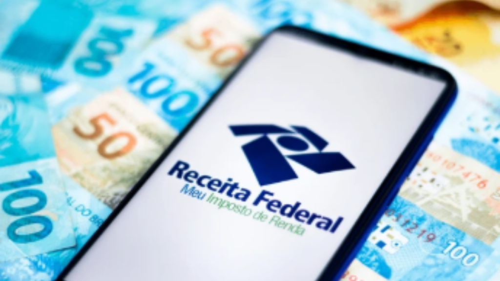 Smartphone exibindo a tela inicial do aplicativo Meu Imposto de Renda para consulta de saldo e lotes de restituição.