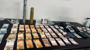 Materiais apreendidos pela Força Tática em Americana, incluindo tijolo de cocaína, maços de dinheiro e máquinas de cartão de crédito utilizados no tráfico de drogas.