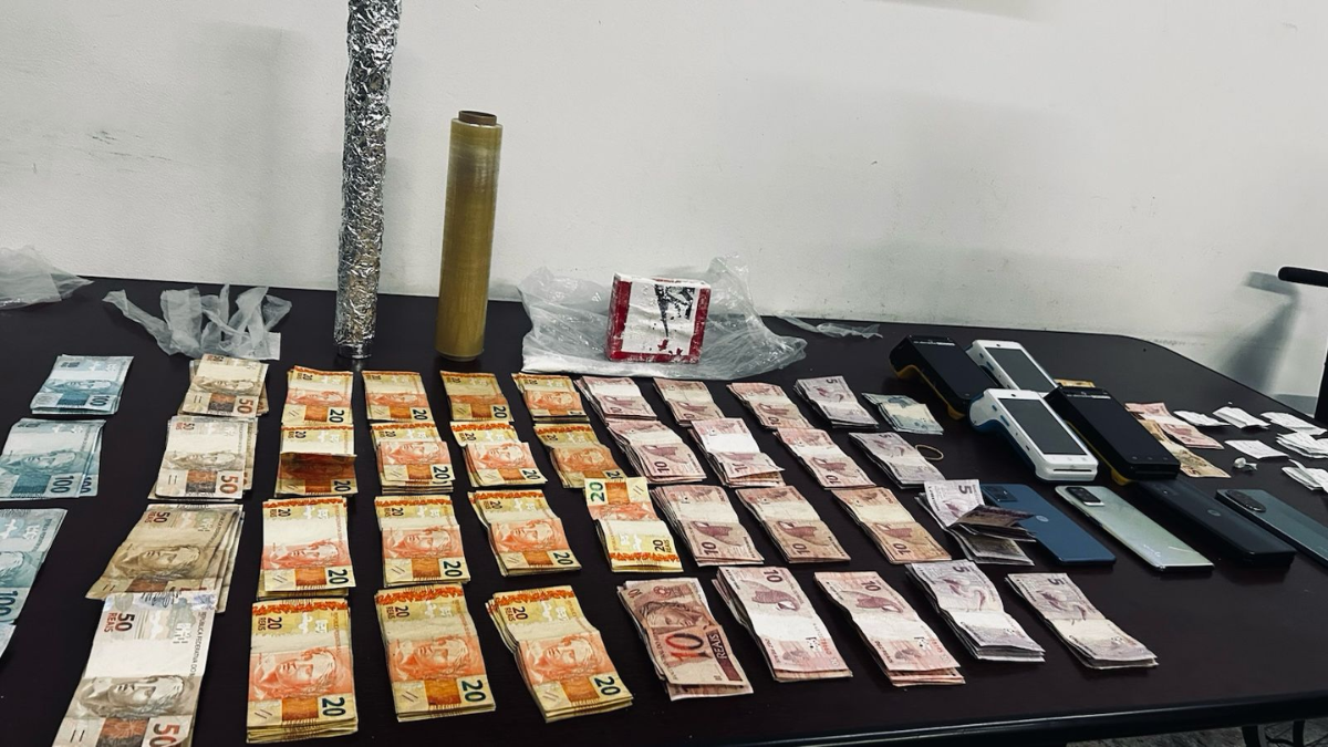 Materiais apreendidos pela Força Tática em Americana, incluindo tijolo de cocaína, maços de dinheiro e máquinas de cartão de crédito utilizados no tráfico de drogas.