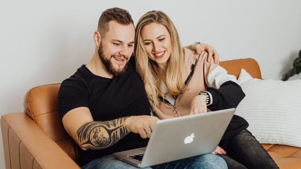 Mãos segurando um notebook com interface de aplicativo de mensagens, ilustrando como a tecnologia e as redes sociais facilitam novas conexões amorosas.