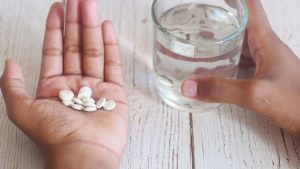 Comprimidos de maleato de enalapril e embalagem de medicamento para pressão alta, contextualizando o alerta de recolhimento de lotes emitido pela Anvisa.