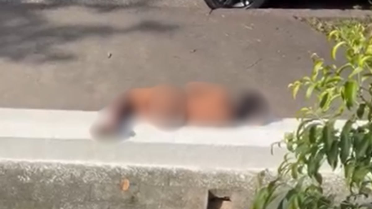 Pessoa em situação de vulnerabilidade social deitada na calçada da Avenida Washington Luiz, no bairro Gonzaga, em Santos.