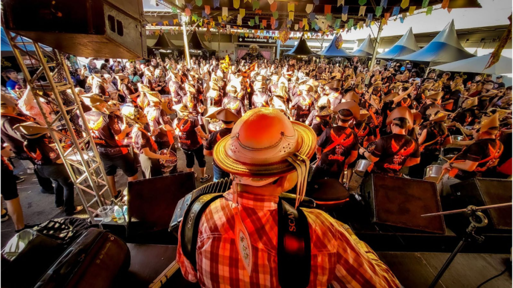 Estrutura de festa junina no estacionamento do Shopping Prado Boulevard com barracas gastronômicas e palco para shows gratuitos.