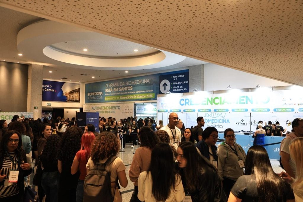 Movimentação de participantes na entrada principal do evento Biomedicina in Santos durante o primeiro dia de atividades científicas.