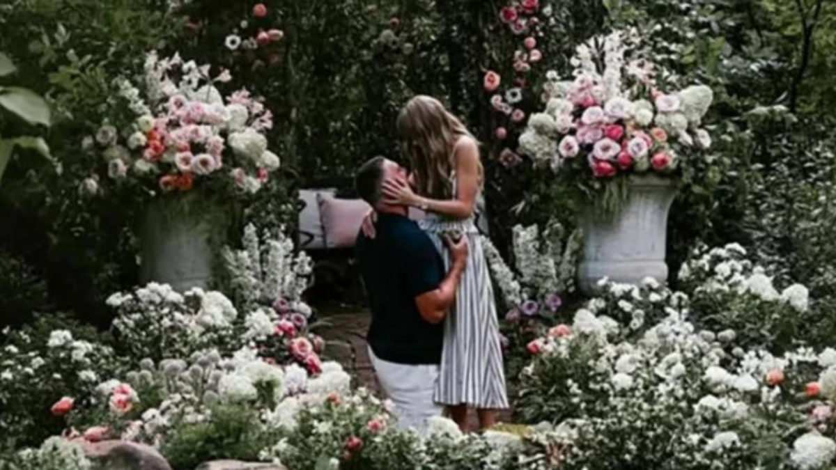 Taylor Swift e Travis Kelce sorrindo juntos em evento público, ilustrando a união do casal e os rumores sobre o casamento planejado para o Madison Square Garden.