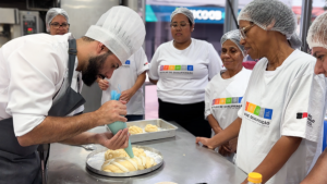 Alunos em atividade prática durante curso de capacitação profissional no Fundo Social de Solidariedade de Santos, representando as oportunidades de aprendizado gratuito em áreas como gastronomia e artesanato.