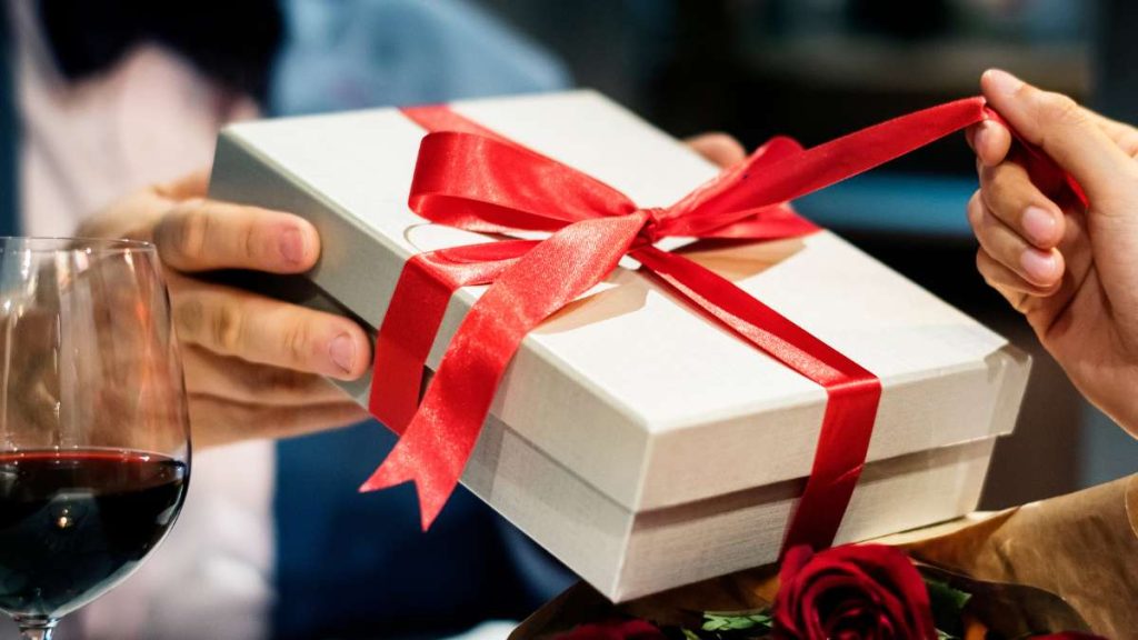 Caixa de presente decorada com laço vermelho, simbolizando a tradição de presentear no Dia dos Namorados e o aumento do tíquete médio no varejo.