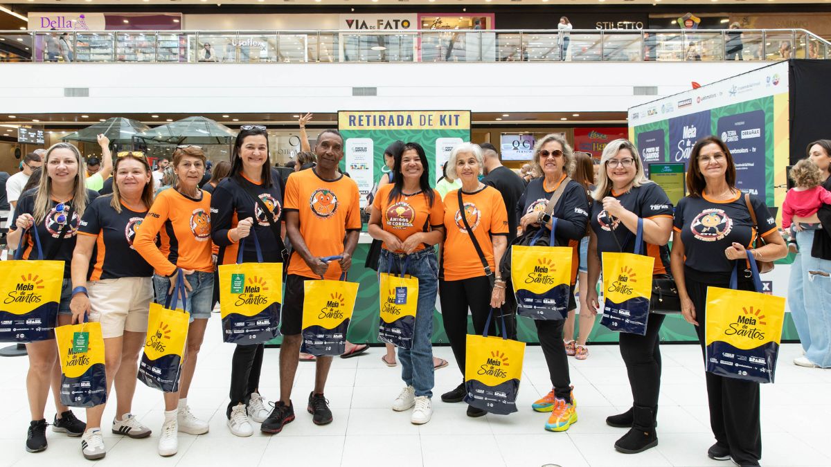 Pessoas no Shopping Parque Balneário, em Santos, retirando o kit da corrida Meia de Santos 2026