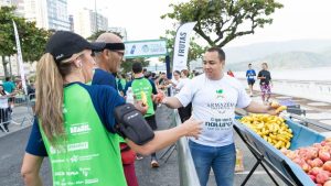 Atletas e público reunidos na área de dispersão da Meia de Santos aproveitando as ativações de pós-prova e lazer.