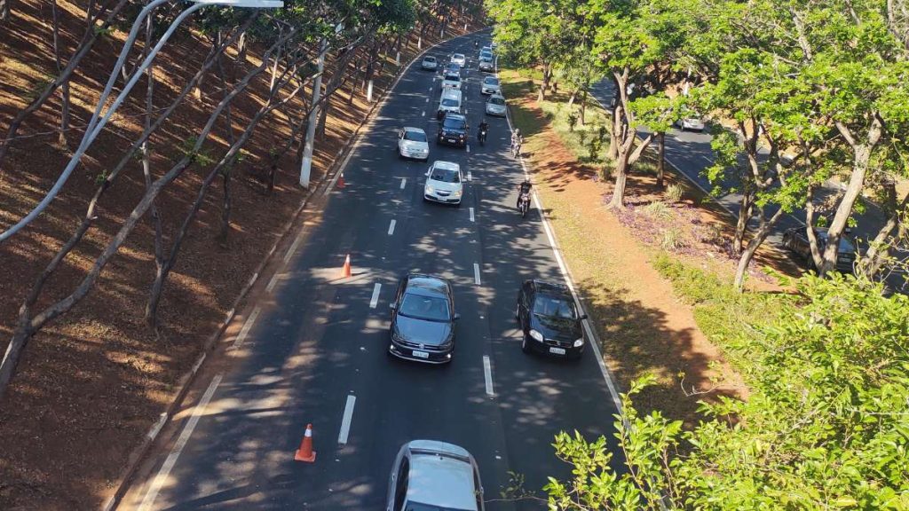Câmera de segurança gravando uma avenida com carros, representando as infrações por uso de celular ao volante.