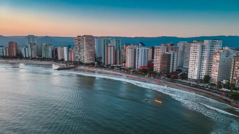 Vista panorâmica da orla de São Vicente, destacando a integração entre a arquitetura urbana e as praias do litoral paulista.