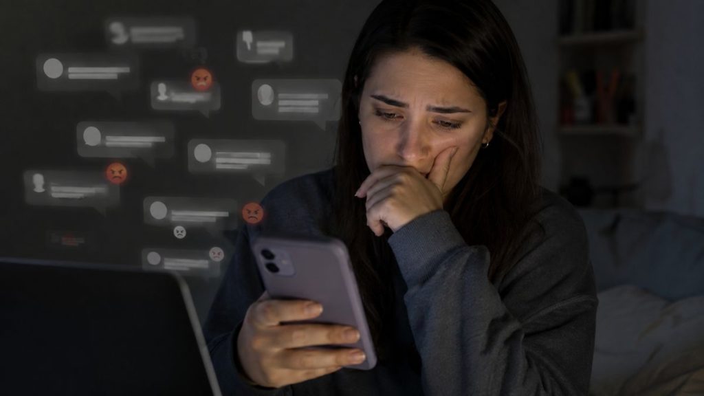 Mulher ao celular nas redes sociais sobre o discurso de ódio que cresce cada vez mais
