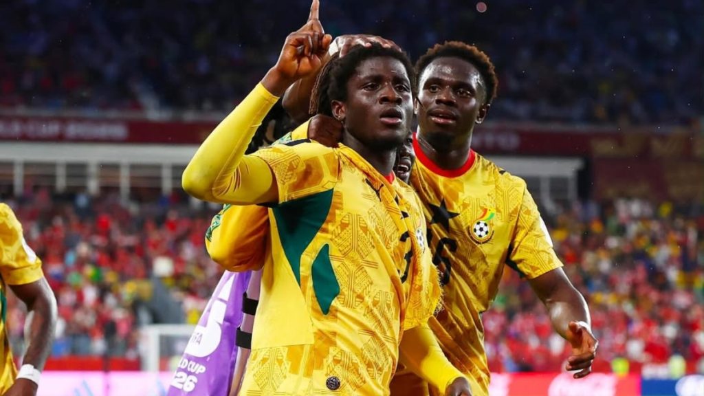 Jogadores da seleção do Gana comemoram vitória em campo, com uniformes amarelos e verdes, abraçando e celebrando durante uma partida contra o Panamá.