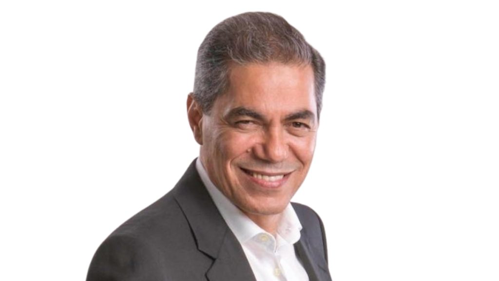 Foto de Edson Moura, natural de Paulínia, sorrindo com terno escuro e camisa branca em imagem de destaque para notícia sobre condenação e prisão em condomínio de luxo no Guarujá.