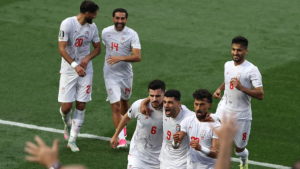 Jogadores da seleção do Irã comemoram em campo em partida de futebol, com atmosfera de reclamação e formalização de protesto à Fifa antes do jogo contra a Bélgica