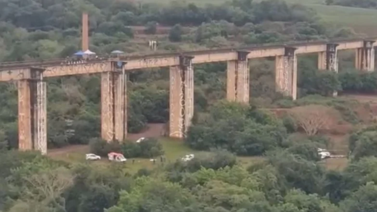 Ponte do Esqueleto vista de longe sobre área verde, com pilares de concreto e faixa em construção, usada para reportagem sobre morte na Ponte do Esqueleto e investigação policial.