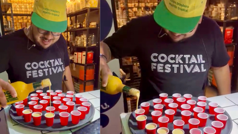 Funcionário da Urbana Coquetelaria em Santos servindo shots em copos vermelhos, com chapéus de festa, durante ação promocional no bar.