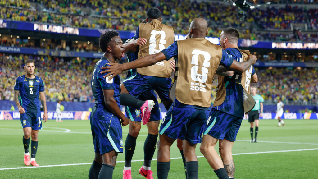 Jogadores da seleção brasileira comemoram um gol no estádio, em partida contra o Haiti, em clima de classificação da Copa, com abraços e uniforme azul e amarelo