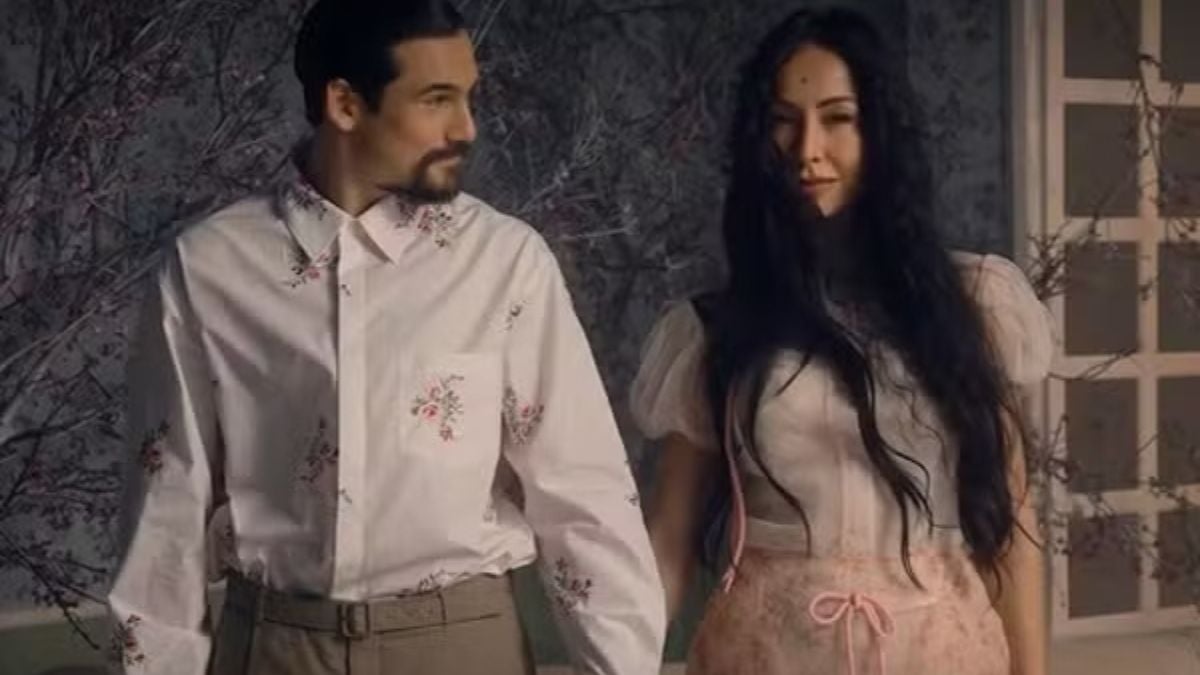 Sabrina Sato grávida aparece ao lado de um homem em um cenário interno, vestindo roupa clara com detalhes, enquanto compartilha anúncio especial ao lado da família