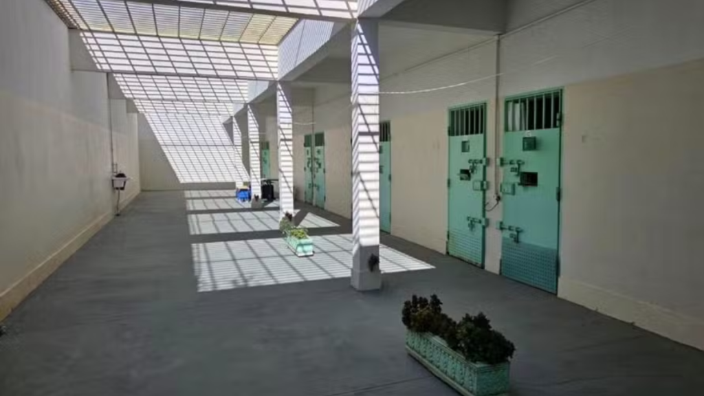Corredor interno do Pavilhão Especial da Penitenciária Feminina de Tupi Paulista, com celas ao fundo e área de circulação cercada por grades, onde Deolane Bezerra está presa preventivamente.
