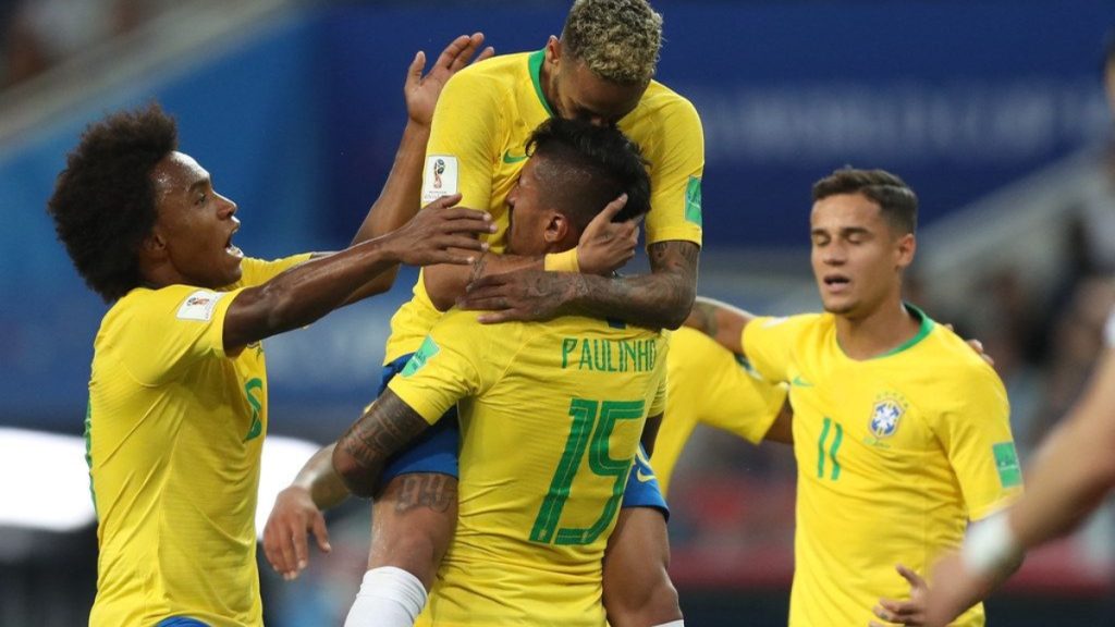 Neymar e a seleção brasileira em partida, comemorando com companheiros no estádio, em imagens de jogo com jogadores de amarelo e azul e destaque para Neymar.