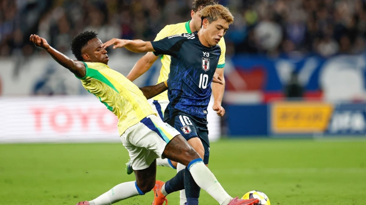 Brasil x Japão na Copa do Mundo 2026: jogador do Japão em disputa de bola contra atleta do Brasil, em partida de futebol com uniforme amarelo e verde e placar ao fundo.