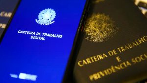 Telefones mostram a Carteira de Trabalho Digital e a Carteira de Trabalho física, com foco em temas trabalhistas; contexto de orientação jurídica para empresas sobre fim da escala 6x1, NR-1 e pejotização.