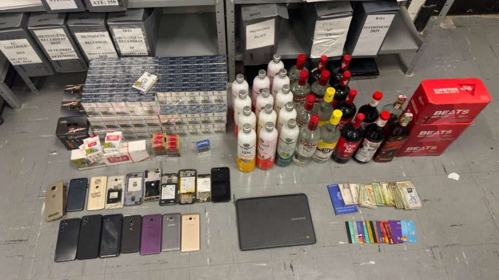 Operação da PM em ferro-velho irregular em Santos: apreensão de celulares, chips, caixas de cigarro e diversos itens como garrafas e caixas de som, evidências de mercadorias sem origem.