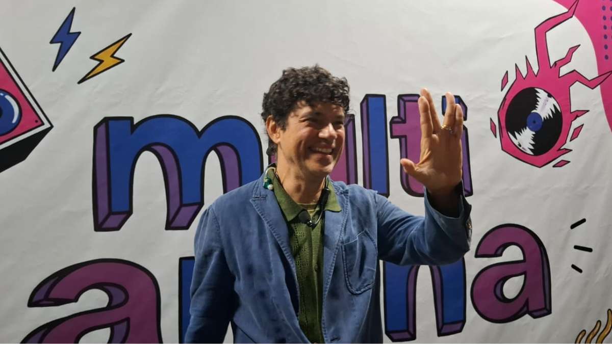Jorge Vercillo em coletiva de imprensa na inauguração do espaço Multi Arena em Campinas fazendo o símbolo JV com as mãos.