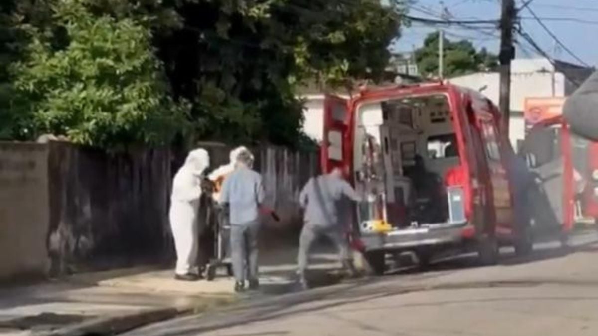 Socorristas e equipe de emergência próximos a uma ambulância vermelha em rua do litoral de São Paulo após um homem ser atacado por enxame de abelhas