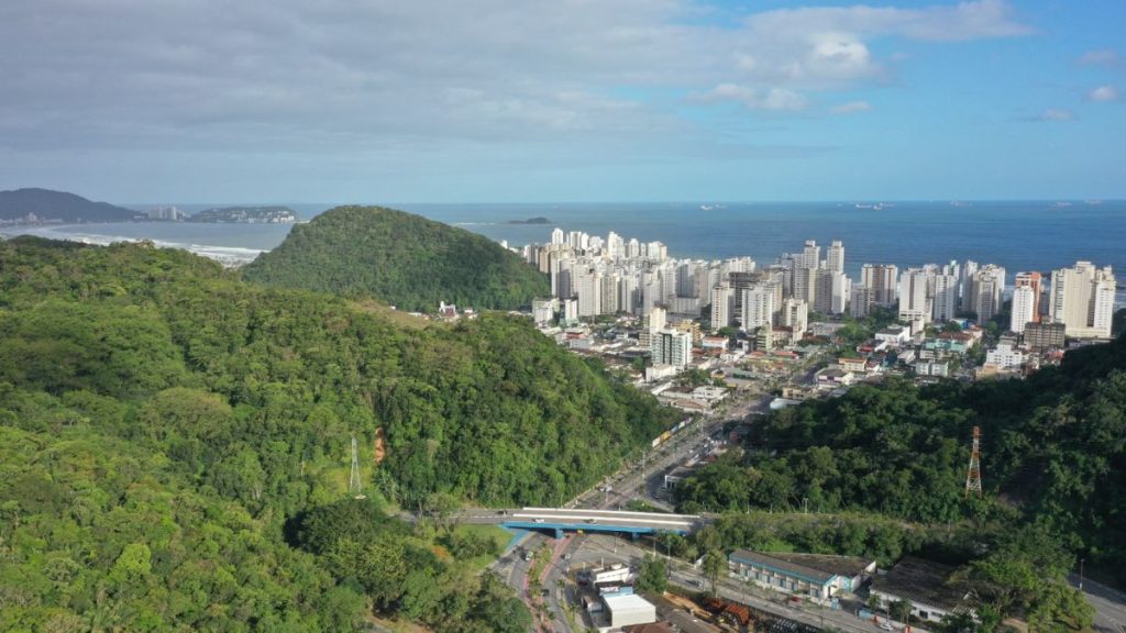 Vista aérea da costa de Guarujá com praia ao fundo e área urbana ao lado de morros e mata atlântica, cenário para Processo seletivo guarda-vidas Guarujá com seleção temporária