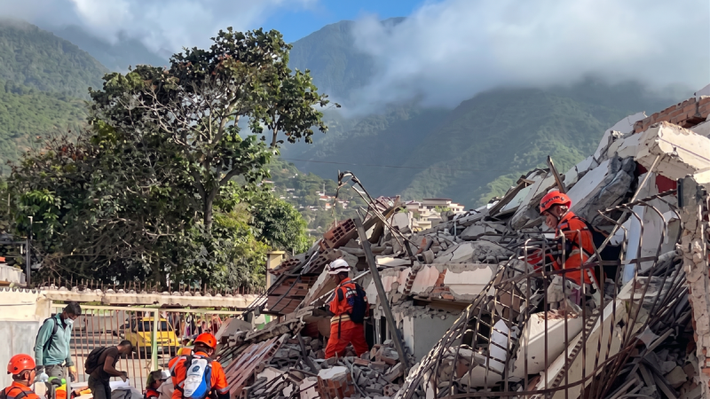 Imagem mostra equipes de resgate trabalhando entre escombros e prédios danificados após terremotos na Venezuela, em contexto de Alerta OMS Venezuela sobre colapso do sistema de saúde.