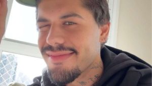 Zé Felipe aparece em close, sorrindo e falando em ambiente interno, com expressão confiante. A imagem destaca a pele e a barba do cantor durante uma explicação sobre isolamento.
