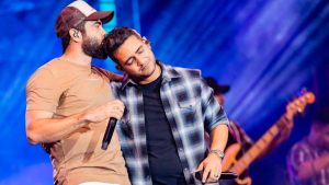 Henrique, da dupla Juliano, aparece em foto durante show ao lado de um parceiro, em clima de backstage, em referência ao período de cirurgia e cancelamento de apresentações.