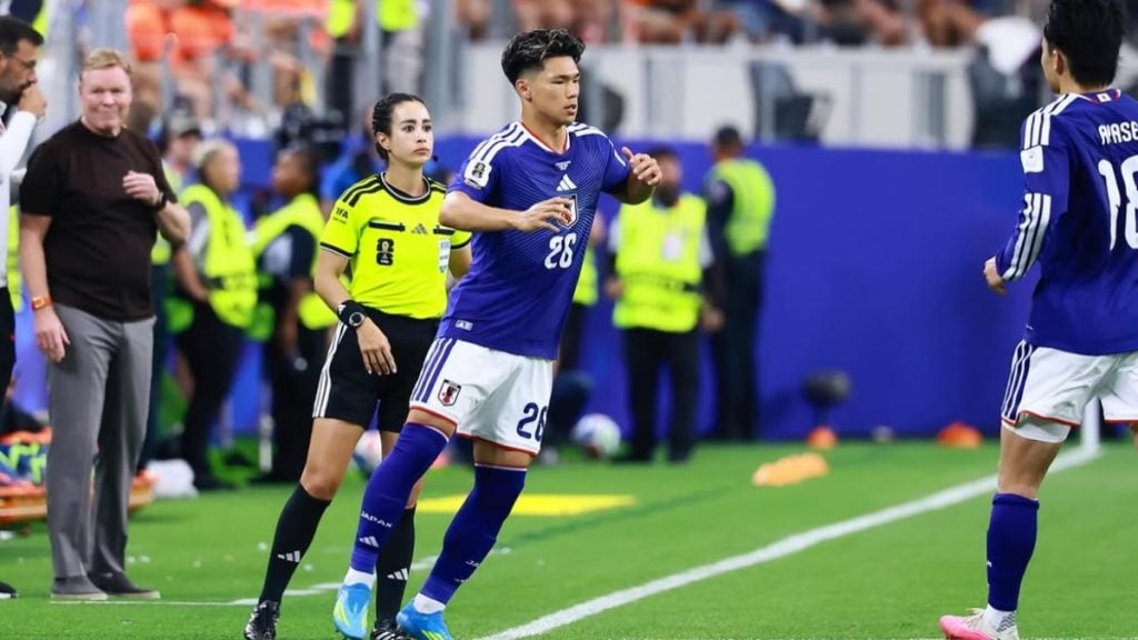Kento Shiogai em campo com a camisa da seleção japonesa durante partida de futebol, reagindo à repercussão no Brasil e chamando atenção para comentários nas redes sociais.